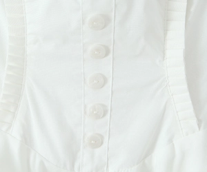 Nahaufnahme der weißen Knöpfe und gerafften Plisseedetails am Neckholder-Kleid