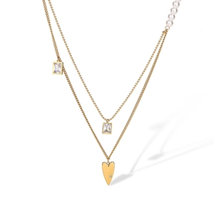Détail d'un collier doré double couche avec pendentif cœur, perles et détails en zircon carré