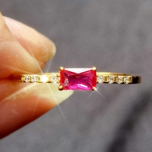 Detailed close-up of a S925 silver gold-plated ring with a red zircon and side stones