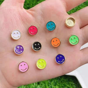 Colorful smiley face charms in drip oil alloy held in hand for DIY jewelry making