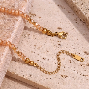 Macro shot of amber faceted crystal beads and golden lobster clasp on adjustable necklace