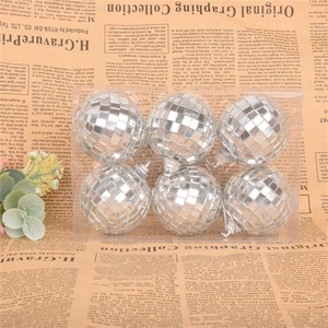 Close-up of six silver disco mirror balls for cake decoration in a clear plastic box