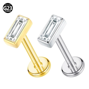 Detail of G23 titanium labret studs in gold and silver with rectangular clear gemstones