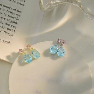 Detail of light blue teardrop crystal and pink round stone set on a metal base