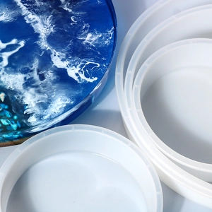 Detail of round silicone resin molds showing various sizes and a blue finished ocean craft