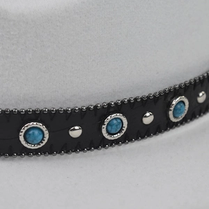 Close-up of wool felt hat band with turquoise stones and silver metallic studs.