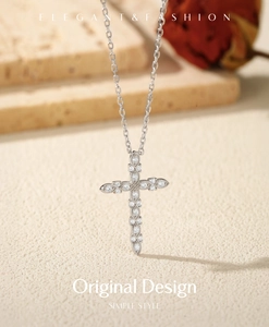 Close-up of S925 silver cross pendant with VVS1 moissanite stones on a stone block