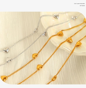Detailed view of elegant gold and silver heart pendant necklaces on textured background