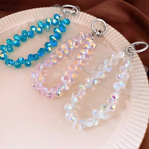 Detailed macro view of colorful crystal beaded phone chains on a beige tray