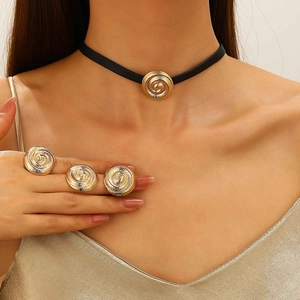 Detail of gold spiral pendant necklace and matching rings on model for beach style