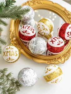 Close-up of glittery XMAS foam balls in red gold and silver on a vintage mirror
