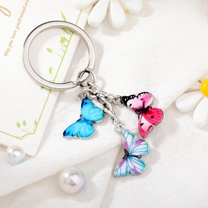 Detail view of colorful enamel butterfly charms on a silver metal keychain with ring