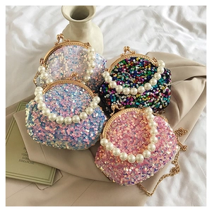 Detail of glitter shell bags with pearl handles in white, blue, black and pink colors