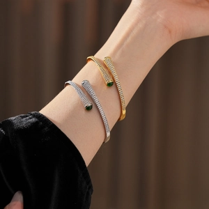 Detail of gold and silver open bangles with pavé zircon and green malachite stones