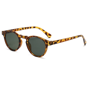 Détail de lunettes de soleil rondes rétro écaillées avec verres vert foncé de profil