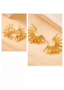 Detail of gold-plated stainless steel fan-shaped geometric earrings on a stone base