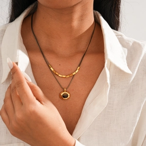 Close-up of 18k gold plated double layer necklace with tiger eye stone pendant on a model
