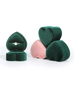 Detailed view of heart-shaped velvet ring boxes in green and pink colors