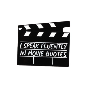 Movie clapperboard enamel pin with 'I speak fluently in movie quotes' text