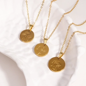 Detailed macro view of three golden titanium steel necklaces with floral oval pendants