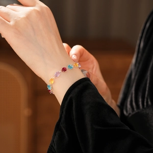 Detailed view of colorful oval-cut zircon bracelet with silver metal claw setting