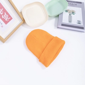 Classic orange ribbed knit beanie hat with a folded cuff displayed on a white background