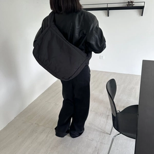 Model wearing a soft black quilted tote bag showcasing its large capacity and retro style