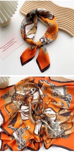 Detail of silk scarf with orange chain print and satin texture on wooden tray