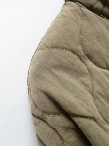 Detail of olive green diamond quilting and stitching on casual winter jacket