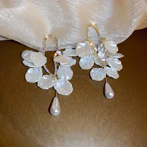 Boucles d'oreilles fleur dorées avec pétales en résine blanche et perles en goutte
