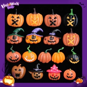 Macro view of fifteen different glowing resin pumpkin beads for Halloween DIY jewelry
