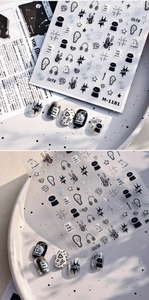 Detail of M-1181 black and white graffiti nail stickers with cat and guitar motifs