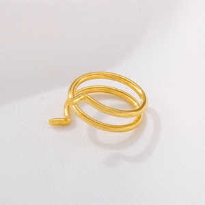 Minimalist double layer golden spiral ring with a high-polished finish on neutral background