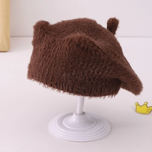 Détail d'un béret en peluche marron avec oreilles d'ours sur un support blanc