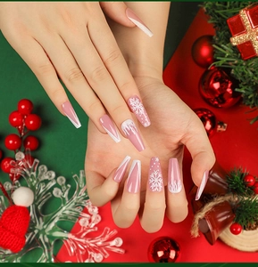 Dettaglio di unghie finte a ballerina lunghe con fiocchi di neve bianchi e glitter rosa
