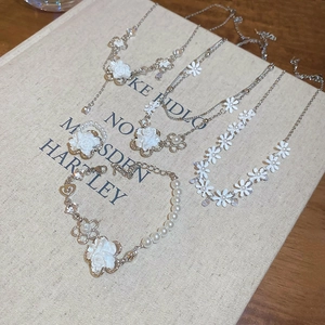 Detail of floral jewelry set with faux pearls and crystals on an open vintage book