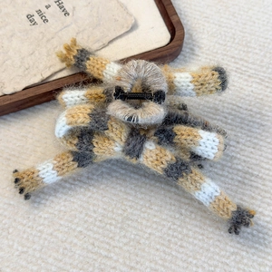 Detail of yellow, grey, and white striped knitted yarn bow hair claw clip for women