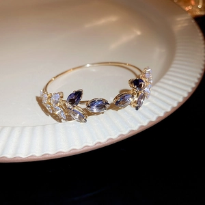 Macro shot of gold leaf cuff bracelet with sparkling purple and clear marquise zircons