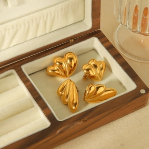 Golden heart-shaped earrings with vintage pleated texture shown in a premium wooden jewelry box