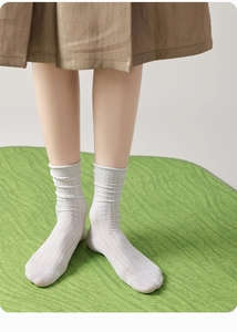 Detail showing white silk ruffled lace socks with vertical striped knit texture