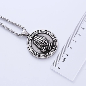 Detailed view of vintage silver praying hands relief pendant with size reference ruler