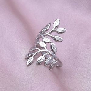 Detailed view of adjustable leaf-shaped stainless steel ring on soft pink silk