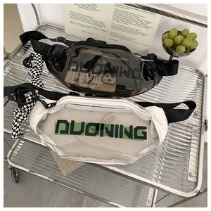 Close-up of clear PVC crossbody waist bags in black and white on a metal cart
