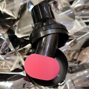 Detailed macro view of a pink mushroom head makeup sponge with a black plastic handle