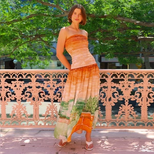 Detail of a summer two-piece set featuring pleated orange tube top and printed long skirt