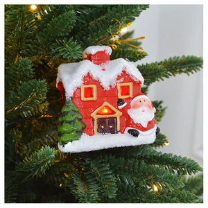 Detail of red and white ceramic house ornament with LED light and miniature Santa