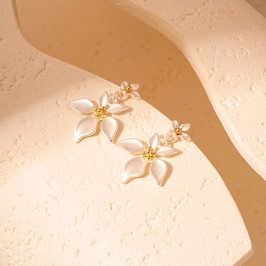 Detail view of floral dangle earrings with silver petals and gold center on stone