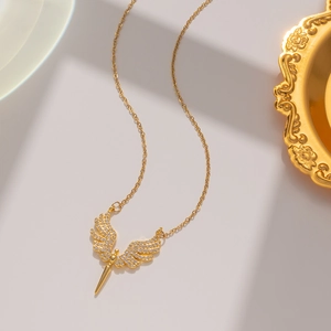 Close-up of golden angel wing pendant with micro-inlaid diamonds on an elegant gold chain