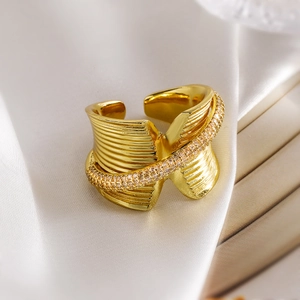 Gold plated geometric wavy open ring with pavé cubic zirconia on white silk backdrop