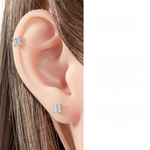 Detail showing light blue zircon flower cartilage earring worn on the earlobe and helix
